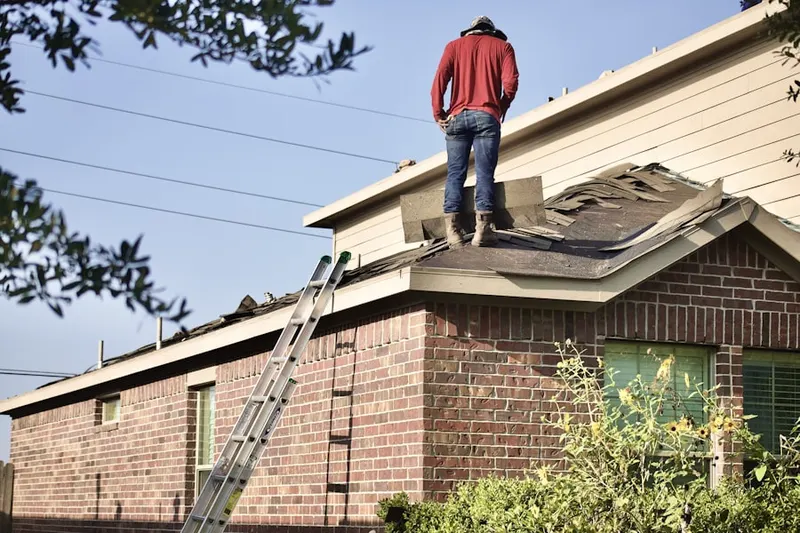 Professional roofer working on a residential roof in Putman Village